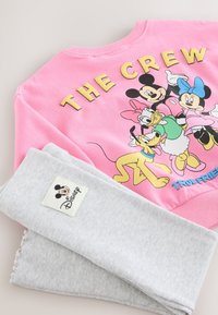 Roosa dressipluus multikatega ja tekstiga "THE CREW". Hallid soonikkoes püksid Disney sildiga. Sile kangas, vabaaja stiil.