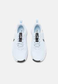 Svijetloplave atletske tenisice od mrežastog materijala s crnim detaljima, dizajna okruglog prsta i bijelim potplatom. Imaju crnu oznaku "Nike" na jeziku.