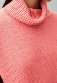 Roze coltrui in een zachte brei. Heeft een geribde kraag en een gladde textuur, die een comfortabele, casual uitstraling benadrukt.