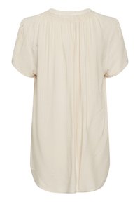 Krämfärgad kortärmad blus med subtilt strukturerad zigzag-mönster och rynkad halsringning sedd bakifrån.