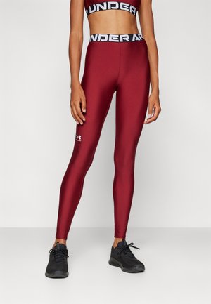 Leggings burdeos con un diseño ajustado, hechos de una tela suave y elástica, con una cinturilla negra con marca y un pequeño logo cerca del tobillo.