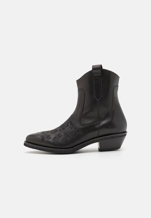 Stivale alla caviglia in pelle nera con ricamo floreale, punta arrotondata, tacco basso impilato e linguetta sul retro per una facile vestibilità.