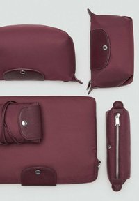 Borse in tessuto marrone di diverse dimensioni, caratterizzate da texture lisce, forme arrotondate e chiusure in metallo a scatto o con cerniera.