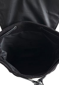 Černá textilní taška s hladkým povrchem, která má kulatý otvor. Interiér je podšitý černou látkou, obsahuje vnitřní kapsu a stahovací šňůrku.