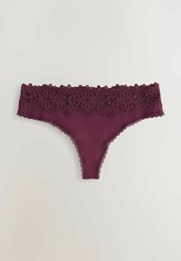 Paarse geribbelde thong ondergoed met kant langs de rand en een bloemenkant tailleband, plat gelegd op een lichte achtergrond.