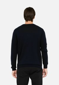 Felpa girocollo blu navy con maniche lunghe, polsini e orlo a coste, realizzata in tessuto morbido, caratterizzata da un design minimalista senza loghi visibili.