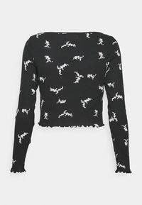 Černý crop top s dlouhým rukávem s bílým abstraktním vzorem. Tkanina má žebrovanou strukturu, s volánkovým lemem a okraji manžet.