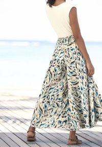 Falda maxi con una cintura fruncida, con un patrón abstracto en azul, crema y marrón. El material parece ligero y fluido.