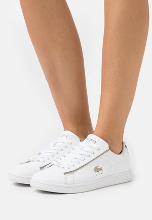 Weiße Ledersneaker mit texturiertem Finish, verziert mit silbernen Akzenten an der Seite und den Schnürsenkeln sowie einem Logo auf der Zunge.