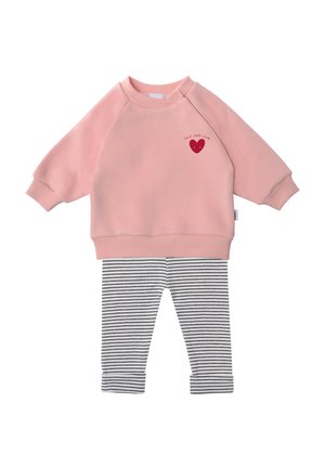 Pink sweatshirt with raglan sleeves featuring a red heart design; paired with black and white striped leggings. Soft fabric, casual style.