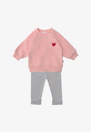 Pink sweatshirt with raglan sleeves featuring a red heart design; paired with black and white striped leggings. Soft fabric, casual style.