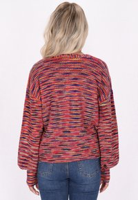 Mehrfarbiger Strickpullover mit lockerer Passform, langen Ärmeln und einem strukturierten Stoff mit roten, blauen und gelben Streifen.