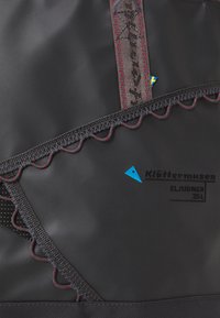 Tissu noir avec une finition texturée, présentant un motif de couture en zigzag, une impression de logo et des détails d'accent colorés. Design lisse et durable.