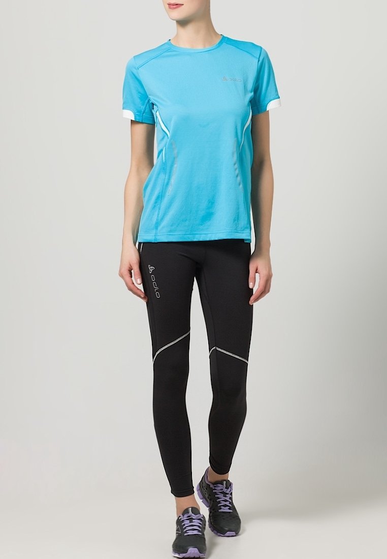 Turquoise short-sleeve athletic shirt with white accents, paired with black leggings featuring reflective seams and logo detail. Black running shoes.