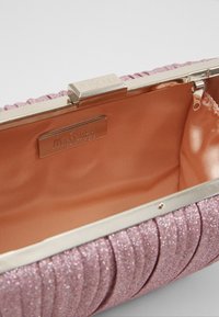 Rosa glittrig kuvertväska med plisserad utsida och guldfärgad detalj. Inuti har den en slät satinfoder, märkt med "MASCARA LONDON."