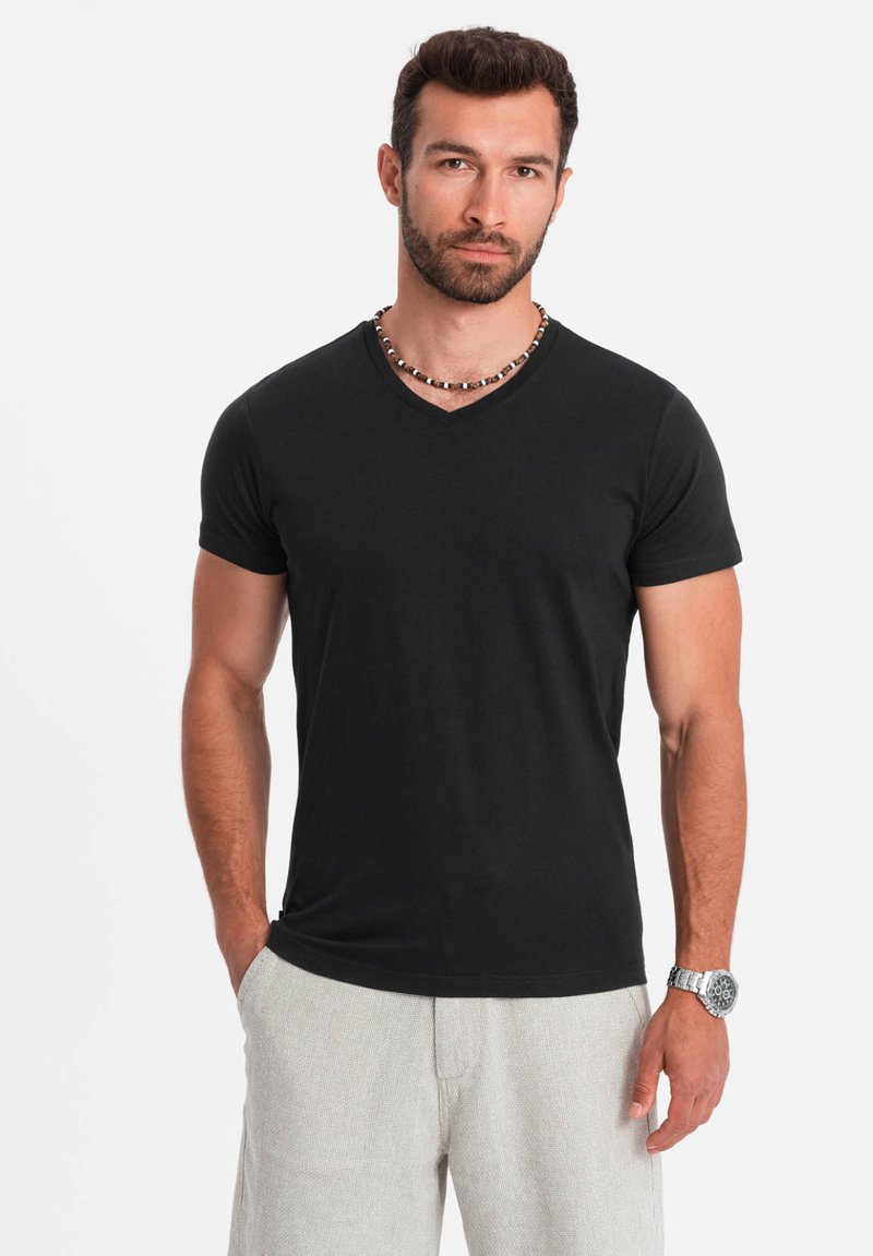 T-shirt nera a maniche corte con scollo a V realizzata in tessuto morbido. Design semplice con vestibilità slim. Dettagli notevoli includono un collo semplice.