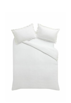 Weißes Bett mit zwei Kissen, jeweils mit gerüschten Rändern, und einer teilweise gefalteten weißen Bettdecke auf einer ebenen Fläche.