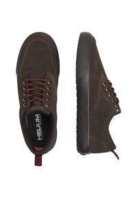 Sneakers in suede marrone con suole in gomma scure, punta rotonda, design con lacci, dettagli rossi e una linguetta a contrasto sul retro.
