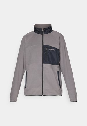 Harmaa fleece-takki, jossa on laivaston sininen rintatasku, vetoketjusuljenta, korkea kaulus ja kontrastiväriset paneelit. Täydennetty elastisilla hihansuilla ja sivutaskuilla.