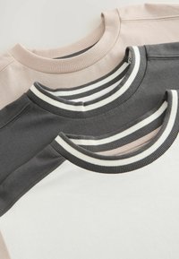 Tre T-shirt impilate, con colli a giro in coste. I colori includono rosa chiaro, grigio scuro e bianco con righe grigie e bianche.