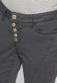 Šedé bavlněné kalhoty slim fit, disponující pěti kovovými knoflíky, šikmými postranními švy a přední kapsou.