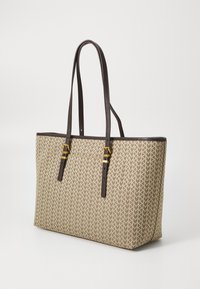 Tote taske i beige stof med et struktureret pilmønster, der har mørkebrune læderremme og detaljer, samt hardware i guldtonede elementer.