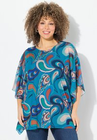 Luftig turkis bluse med farverige paisley-mønstre, korte dolmanærmer, rund hals og en løs pasform, parret med mørke jeans.