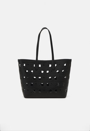 Black tote bag with cut-out pattern and logo detail. Made from synthetic material; features two long handles for carrying.
