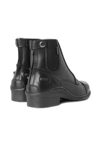 Bottines en cuir noir avec une finition lisse, fermeture éclair latérale, bout rond et un petit talon. Présente des détails de couture et un renforcement à l'arrière.