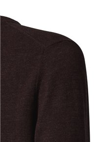 Nahaufnahme eines dunkelbraunen Strickpullover-Stoffes, der sich auf die Schulternaht und die Textur konzentriert.