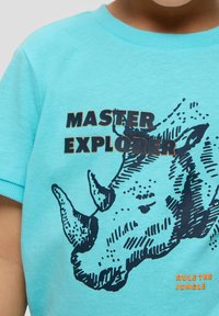 Türkises Baumwoll-T-Shirt mit einer Darstellung eines schwarzen Nashorns und dem Text "MASTER EXPLORER" in fettem Schwarz und Orange. Kurze Ärmel, Rundhalsausschnitt.