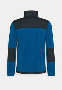 Chaqueta de forro polar azul con un panel superior negro, acentos laterales, cuello alto y mangas largas con parches negros contrastantes.