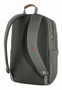 Mochila gris con paneles de malla, que incluye un asa superior de cuero marrón, correas ajustables y un pequeño detalle de logotipo en la parte delantera.