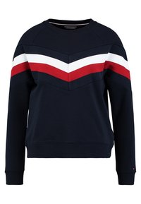 Felpa marina con motivo a zigzag in rosso, bianco e blu scuro. Presenta dettagli a coste e un collo rotondo. Tessuto morbido con maniche lunghe.