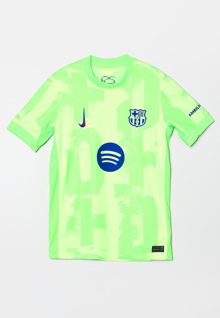 Jasnozielona koszulka z krótkim rękawem z abstrakcyjnymi wzorami, z niebieskim logo Spotify, herbem FC Barcelony oraz logo Nike z przodu.