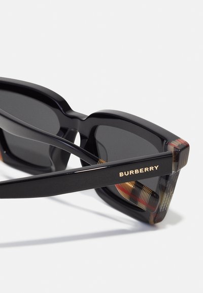 Black rectangular sunglasses with a thick frame. Inner side displays a plaid pattern in red and beige. Gold "BURBERRY" branding on arm.