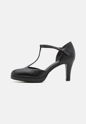 Schwarze Leder-Pumps mit abgerundetem Zehenbereich, T-Riemen-Design und Plattformsohle, die eine glänzende Oberfläche und einen stabilen Absatz aufweisen.