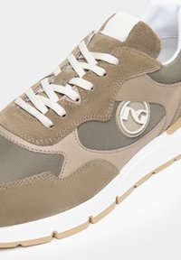 Beige sneakers med en kombination av mocka och mesh-material, vita snören, vadderad krage och en logotypdetalj på sidan. Gummisula.