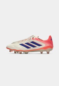 Valgete ja roosade Adidas Copa jalgpallijalatsite külgvaade siniste triipude ja kengadega, valgel taustal.