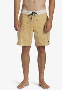 Pantaloni da bagno gialli con un motivo a righe e a diamante, caratterizzati da un elastico in vita con coulisse e un tessuto leggero. Comprendono tasche laterali.