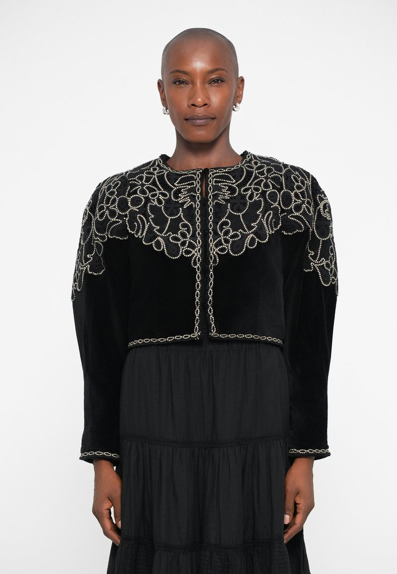 Black velvet cropped jacket adorned with intricate silver embroidery and beading, featuring a round neckline and long sleeves.