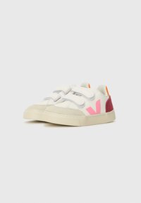 Hvit sneakers med borrelås, med rosa og oransje detaljer, en teksturert gummisåle og myke semskede detaljer på sidene.