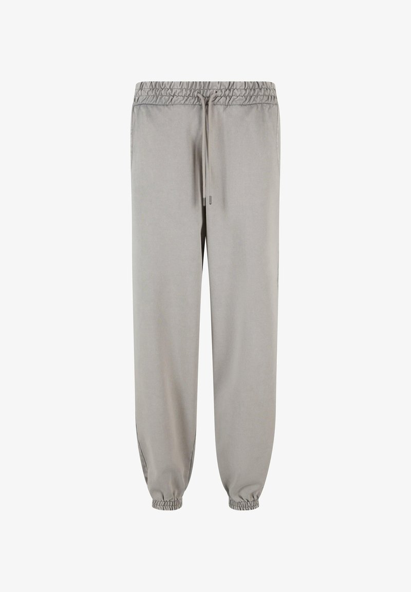 Jogging léger gris fabriqué en tissu doux, avec une taille élastique dotée de cordons de serrage et des poignets élastiques aux chevilles.