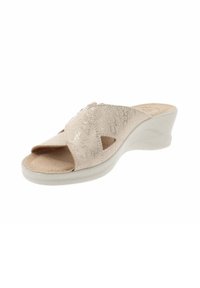Sandalo beige con tacco a zeppa, design con fascia incrociata, tomaia testurizzata, punta aperta e suola bianca sagomata. Presenta dettagli a taglio sulle fasce.