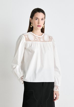 Weiße Baumwollbluse mit langen Ärmeln, die mit filigranen Spitzendetails am Ausschnitt und an den Manschetten versehen ist, und einer lockeren Passform.