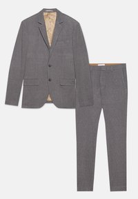 Grå dress bestående av en teksturert blazer med to frontlommer og matchende skreddersydde bukser. Blazeren har en lys indre foring.