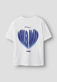 T-shirt en coton blanc avec un graphique bleu au dos. Le texte indique "VERSION 2.0" au-dessus d'un cœur stylisé et "CPMHGN" en dessous. Manches courtes.