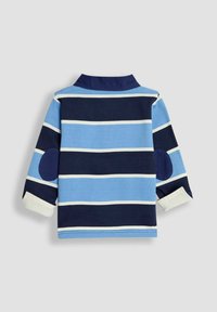 Pitkähihaista paitaa sinivalkoraidallisena, jossa on kaulus, valkoisia yksityiskohtia ja tummansiniä kyynärpääpaikkoja, on valmistettu pehmeästä puuvillamateriaalista.