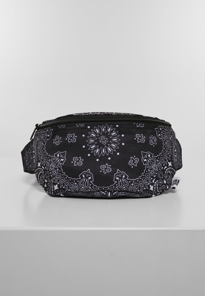 Sac en tissu noir avec un motif bandana blanc, forme arrondie, fermeture éclair et poignée latérale pour un transport facile.