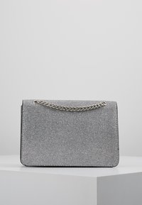 Borsa a tracolla argento con forma rettangolare, superficie testurizzata e tracolla in catena argentata. Design compatto con chiusura a patta.